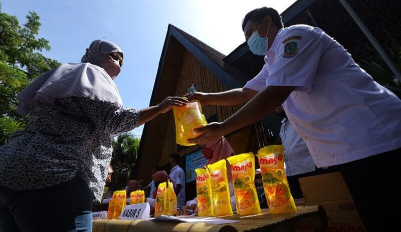 Warga membeli minyak goreng pada operasi pasar stabilisasi harga minyak goreng di Rumah kreatif, Banyuwangi, Timur, Senin (24/1/2022). Operasi pasar untuk menstabilisasikan harga minyak goreng kemasan dengan harga Rp14 ribu per liter oleh Dinas Koperasi, Usaha Mikro dan Perdagangan setempat itu sepi pembeli dikarenakan sudah banyak toko ritel yang bekerjasama dengan Kementerian Perdagangan menjual dengan harga murah. ANTARA FOTO/Budi Candra Setya/hp.