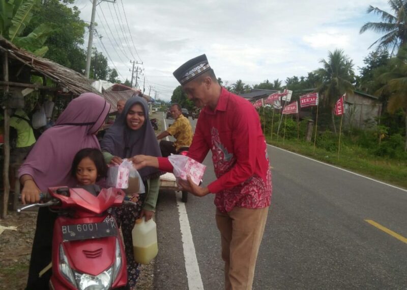 Sardiman Anggota DPRK Abdya saat membagikan takjil kepada warga yang melintas di jalan raya