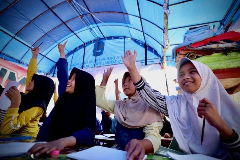 Foto : Anak-anak Desa Mangunkerta, Kecamatan Cugenang, mengikuti senam pagi sebelum mengikuti Kegiatan Belajar Mengajar (KBM) di tenda darurat yang didirikan di lapangan bola basker SMP Negeri 1 Cugenang, Jumat (2/12). 
