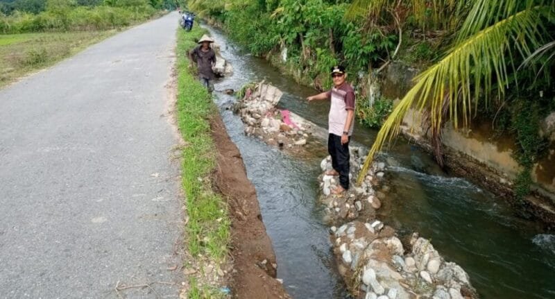 Keuchik Zulkifli menunjukkan tanggul pengaman tebing jalan ambruk diterjang banjir di Gampong Kuta Bakdrien Aceh Barat Daya, Ahad (5/3/2023)