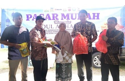 Kasi analis perdagangan Diskopukmdag Aceh Besar Abdul Hadi, SE menyerahkan paket secara simbolis paket pasar khusus kepada salah satu pembeli di Pasar Krueng Raya, Kecamatan Mesjid Raya, Aceh Besar, Kamis (6/6/2024). FOTO/MC ACEH BESAR