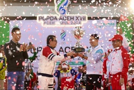 Penjabat Sekretaris Daerah Aceh, Azwardi AP, M.Si., atas nama PJ Gubernur Aceh menyerahkan piala bergilir kepada Kota Banda Aceh yang keluar sebagai juara umum  pada Pekan Olahraga Pelajar Daerah (POPDA) Aceh ke-XVII Tahun 2024, Di Gedung Idi Sport Center (ISC), Aceh Timur, Jumat, 12/7/2024.