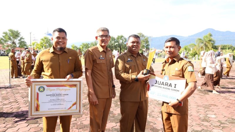 Pj Bupati Aceh Besar Muhammad Iswanto, S.STP MM yang diwakili Sekdakab Aceh Besar Drs Sulaimi MSi menyerahkan hadiah dan penghargaan kepada keuchik Bueng Sidom, Kecamatan Blang Bintang, setelah meraih juara pertama pada ajang lomba gampong tingkat Provinsi Aceh tahun 2024 di seusai Apel Gabungan Organisasi Perangkat Daerah di halaman Kantor Bupati Aceh Besar, Senin (26/8/2024).