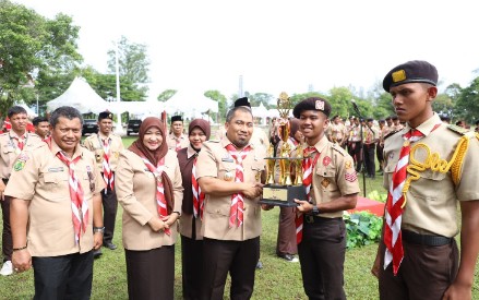 Pj Bupati Aceh Besar Muhammad Iswanto SSTP MM menyerahkan Piala Juara Umum Penggalang kepada Peserta Kemah Budaya Aceh Besar 2024 di lapangan Bungoeng Jeumpa, Kota Jantho, Kabupaten Aceh Besar, Minggu (18/8/2024). FOTO/ PROKOPIM PEMKAB ACEH BESAR