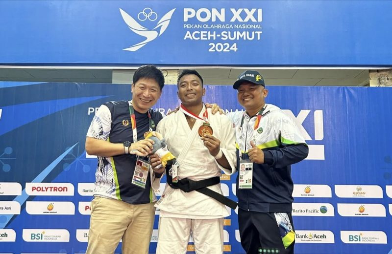 Peraih medali emas cabang olahraga judo nomor-90 kilogram putra PON XXI, I Kadek Pasek Karisna (tengah) saat berfoto bersama usai memenangkan laga final di Gelanggang Mahasiswa Universitas Syiah Kuala (USK), Banda Aceh, Aceh, Rabu (11/9/2024). Foto: Ist 