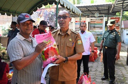 Pj Bupati Aceh Besar Muhammad  Iswanto SSTP MM didampingi Kadis Pangan Aceh Besar Alyadi SPi MM  dan Forkopimcam Kuta Baro menyerahkan secara simbolis sembako kepada masyarakat di pasar murah yang digelar Pemkab Aceh Besar dan Perum Bulog Kanwil Aceh di Halaman Meunasah Gampong Beung Bak Jok, Kecamatan Kuta Baro, Aceh Besar, Selasa (29/10/2024). FOTO/MC ACEH BESAR