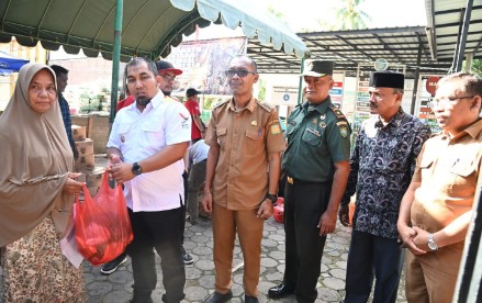 Pj Bupati Aceh Besar Muhammad  Iswanto SSTP MM didampingi Kadis Pangan Aceh Besar Alyadi SPi MM  dan Forkopimcam Kuta Baro menyerahkan secara simbolis sembako kepada masyarakat di pasar murah yang digelar Pemkab Aceh Besar dan Perum Bulog Kanwil Aceh di Halaman Meunasah Gampong Beung Bak Jok, Kecamatan Kuta Baro, Aceh Besar, Selasa (29/10/2024). FOTO/MC ACEH BESAR