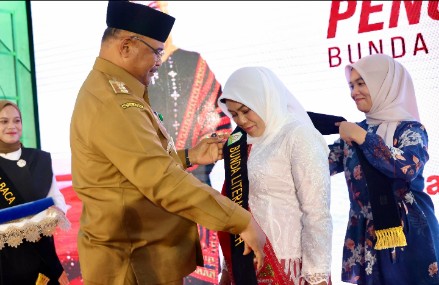 Penjabat Gubernur Aceh Dr. H. Safrizal ZA, M.Si., mengukuhkan Hj. Safriati, S.Si, M.Si sebagai Bunda Literasi Aceh, di Perpustakaan Wilayah Aceh, Selasa, 5/11/2024.