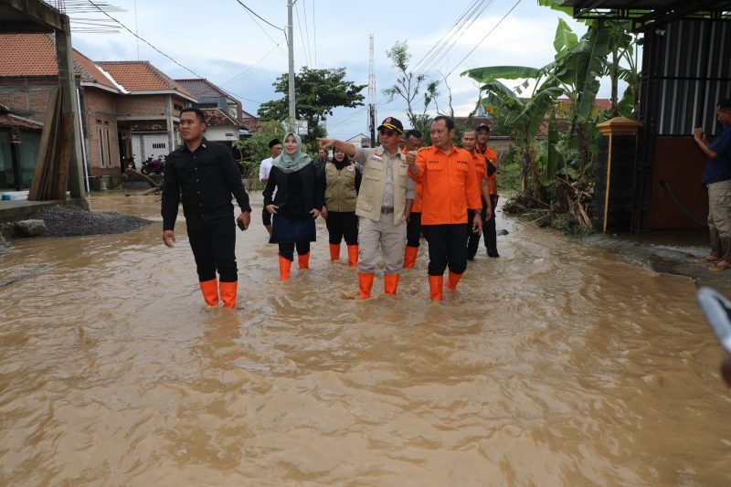 Kepala BNPB Letjen TNI Dr. Suharyanto, S.Sos., M.M. (kemeja dan jaket krem) saat meninjau lokasi yang masih tergenang banjir di Kecamatan Ponorogo, Kabupaten Ponorogo, Jawa Timur pada Senin (16/12).