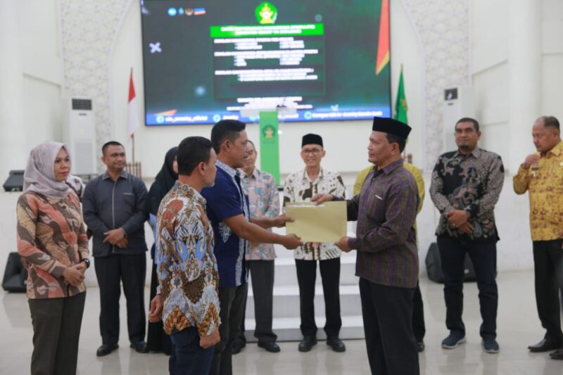 Staf Ahli Bupati Aceh Besar Bidang Perekonomian, Keuangan, dan Pembangunan, Ir. Makmun MT, menyerahkan daftar mahasiswa PPKPM FTK UIN Ar-Raniry Banda Aceh semester genap tahun ajaran 2024-2025 kepada camat di Auditorium Prof Ali Hasjmy UIN Ar-Raniry, Kamis (9/1/2025). Foto: Dok. MC Aceh Besar