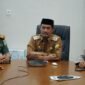 Wakil Bupati Aceh Besar Drs Syukri A Jalil mengikuti Rapat Koordinasi (Rakor) Langkah Konkret Pengendalian Inflasi Daerah dan Akselerasi Sertifikasi Produk Halal secara virtual di ruang kerjanya di Kota Jantho, Selasa (04/03/2024). Foto: Dok. MC Aceh Besar