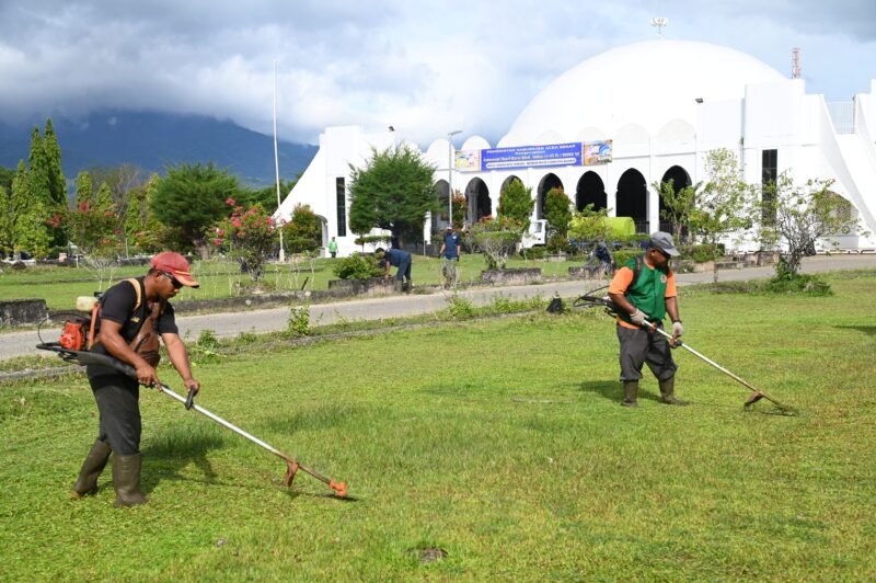Petugas kebersihan DLH Aceh Besar bergotong royong membersihkan rumput dalam rangka menyambut Hari Lingkugan hidup Sedunia di halaman Masjid Al Munawwarah Kota Jantho, Aceh Besar, Rabu (04/06/2025). FOTO/MC ACEH BESARPetugas kebersihan DLH Aceh Besar