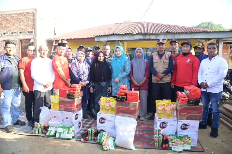 Ketua TP PKK Aceh Besar Hj Rita Mayasari menyerahkan bantuan masa panik kepada korban bencana angin kencang, di Lampasi Engking, Kecamatan Darul Imarah, Kabupaten Aceh Besar, Jumat (13/6/2025). FOTO/ MC ACEH BESAR