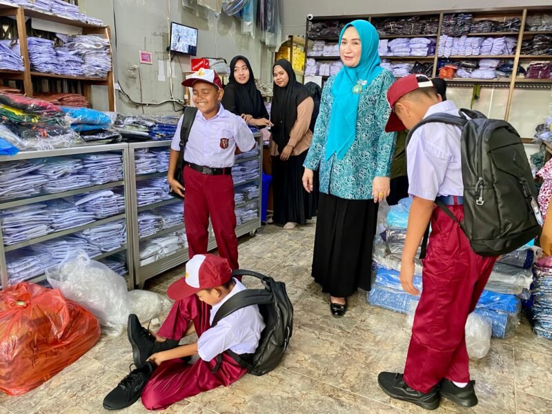 Marlina Muzakir, Bunda PAUD Aceh, membantu memilihkan sepatu dan seragam baru untuk tiga siswa SD di Blangpidie, Selasa 17/6. Aksi spontan ini dilakukan setelah ia melihat sepatu lusuh mereka saat sosialisasi pola makan sehat di sekolah.