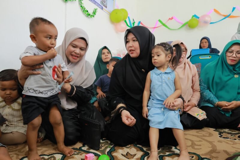 Ketua Pembina Posyandu Kabupaten Aceh Besar, Hj Rita Mayasari, berdialog dengan seorang balita pada Posyandu Aneuk 'Nda di Gampong Lampantee, Kecamatan Seulimeum, Kabupaten Aceh Besar, Selasa (17/6/2025). FOTO/ MC ACEH BESAR