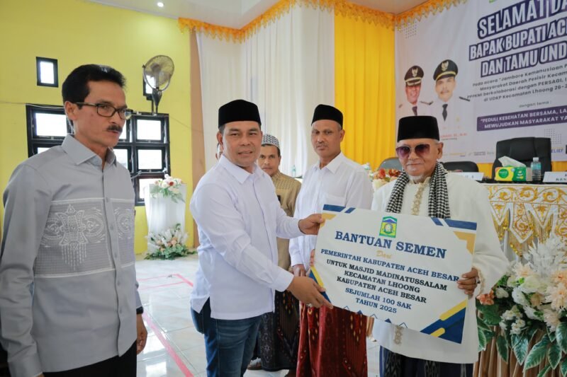Bupati Aceh Besar H Muharram Idris (Syech Muharram), menyerahkan secara simbolis bantuan untuk masjid di Lhoong, usai membuka Jambore Kemanusiaan Peduli Kesehatan Masyarakat Daerah Pesisir di Gedung UDKP Kecamatan Lhoong, Kabupaten Aceh Besar, Sabtu (26/7/2025). FOTO/ MC ACEH BESAR