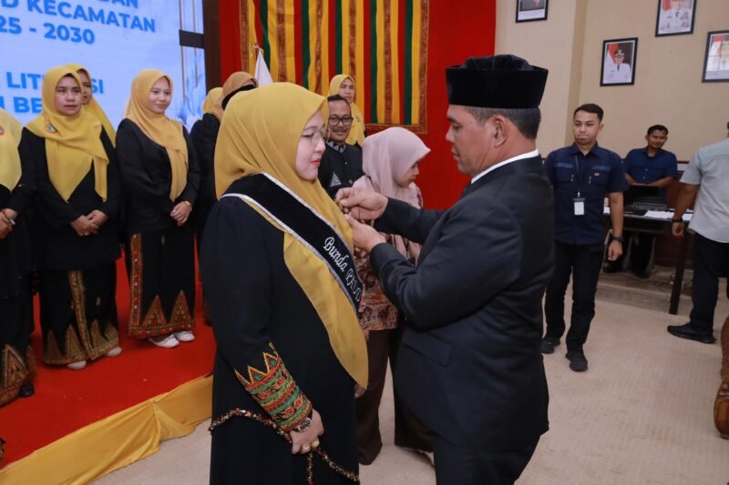 Bupati Aceh Besar H Muharram Idris (Syech Muharram) memasangkan slempang Bunda PAUD Aceh Besar, kepada Hj Rita Mayasari, di Meuligo Bupati Aceh Besar, Kota Jantho, Kamis (14/8/2025). FOTO/ PROKOPIM PEMKAB ACEH BESAR
