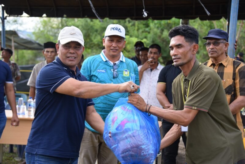Bupati Aceh Besar H Muharram Idris (Syech Muharram), di dampingi Kadisparpora Aceh Besar Abdullah SSos, menyerahkan peralatan olahraga kepada panitia pelaksana turnamen sepakbola HUT ke-30 Kemukiman Lamteuba, di Lapangan Keumeureuk, Gampong Lam Apeng, Kemukiman Lamteuba, Kecamatan Seulimeuem, Kabupaten Aceh Besar, Sabtu (23/8/2025). FOTO/ MC ACEH BESAR