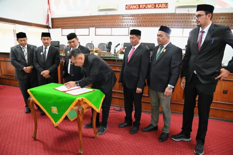 Bupati Aceh Besar, H Muharram Idris menyampaikan tanggapan terhadap rancangan Qanun tentang pengelolaan keuangan daerah dan rancangan Qanun tentang penyelenggaran cadangan pangan di Ruang Rapat Paripurna DPRK, Jumat (19/09/2025). FOTO/MC ACEH BESAR