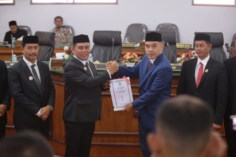 Bupati Aceh Besar Muharram Idris menyerahkan nota keuangan rancangan qanun tentang perubahan anggaran pendapatan dan belanja Kabupaten Aceh Besar tahun 2025 pada rapat paripurna ke-7 DPRK Aceh Besar masa persidangan ke-1 tahun sidang 2025-2026 diterima Ketua DPRK Aceh Bedar Abdul Mukcti, di Gedung DPRK Aceh Besar, Kota Jantho, Rabu (25/9/2025). FOTO/MC ACEH BESAR