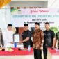 Bupati Aceh Besar, H Muharram Idris menerima Sertifikat Halal dari Ketua MPU Aceh Tgk H Faisal Ali dalam acara Launching Sertifikat Halal Rumah Potong Hewan Lambaro, Kecamatan Ingin Jaya, Aceh Besar, Jumat (31/10/2025). FOTO/MC ACEH BESAR