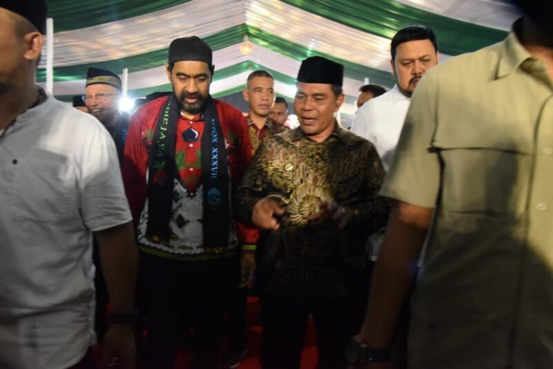 Bupati Aceh Besar H Muharram Idris (Syech Muharram) berdialog dengan Gubernur Aceh Muzakir Manaf (Mualem), pada gala dinner pembukaan MTQ XXXVII tingkat Provinsi Aceh tahun 2025, di halaman Kantor Bupati Pidie Jaya, Sabtu (1/11/2025) malam. FOTO/ MC ACEH BESAR