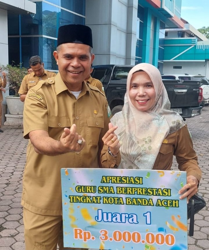 Plt Dinas Pendidikan Aceh, Murthalamuddin, S.Pd., M.SP, menyerahkan apresiasi kepada guru SMA berprestasi tingkat Kota Banda Aceh pada Senin (24/11/2025) di halaman kantor Dinas Pendidikan Aceh.