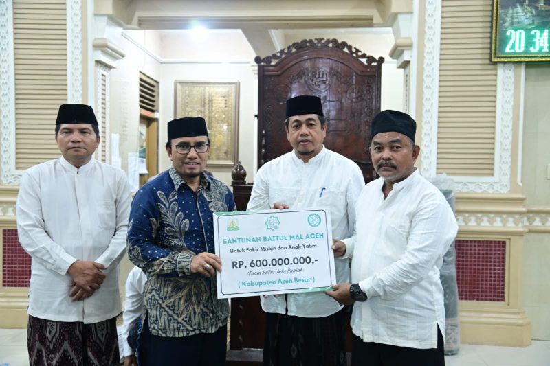 Plt Kepala Dinas Syariat Islam Aceh, Marzuki, S.Ag., M.H., secara simbolis menyerahkan bantuan tersebut kepada Asisten II Sekretaris Daerah Kabupaten (Sekdakab) Aceh Besar, M. Ali, S.Sos., M.Si. Turut hadir dalam acara Tgk. H. Faisal Ali (Abu Sibreh)