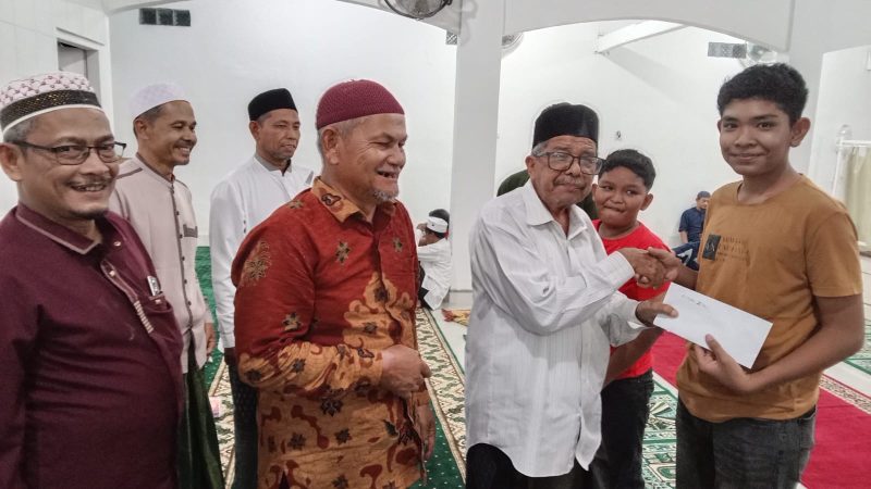 Penyerahan Santunan Anak Yatim Secara Simbolis Oleh Tgk. H. Marwan Imum Meunasah Leu Ue  Pada Peringatan Nuzulul Qur'an Di Menasah Gampong Leu Ue, Darul Imarah, Aceh Besar, Sabtu, (14/03/2025).