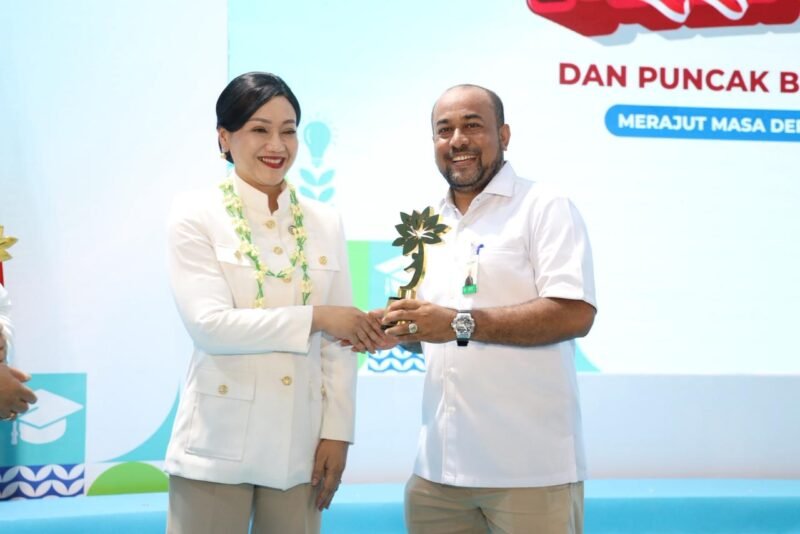 Ketua Dewan Komisioner Otoritas Jasa Keuangan (OJK), Friderica Widyasari Dewi, kepada Direktur Utama Bank Aceh Syariah, Fadhil Ilyas. Penyerahan berlangsung dalam rangkaian acara Puncak Hari Indonesia Menabung dan Bulan Literasi Keuangan 2026 di Sekolah Rakyat 13 Bekasi, Jumat (28/8/2026).