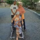 Sariana Hasibuan, lansia 76 tahun, menggunakan kursi roda bantuan Pemerintah Aceh melalui Dinas Sosial Aceh, didampingi anggota keluarga di Banda Aceh, Kamis (24/9/2026). Foto: (Dinsos Aceh).